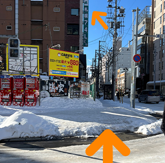 左向かえに駐車場がある交差点に来ましたら左折します。緑色の看板が目印です。